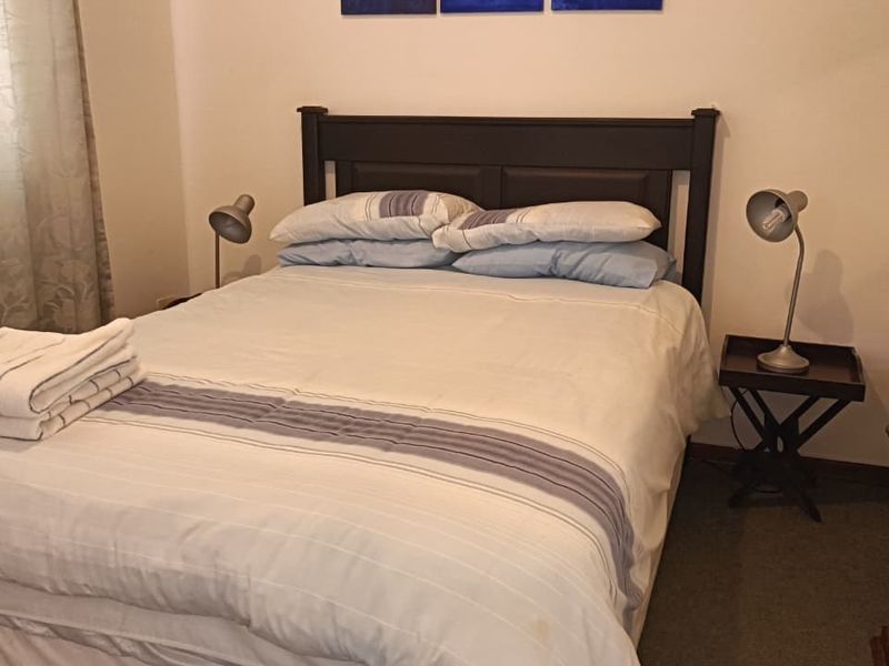A standard bedroom featuring neutral wall finishes and carpeted flooring.