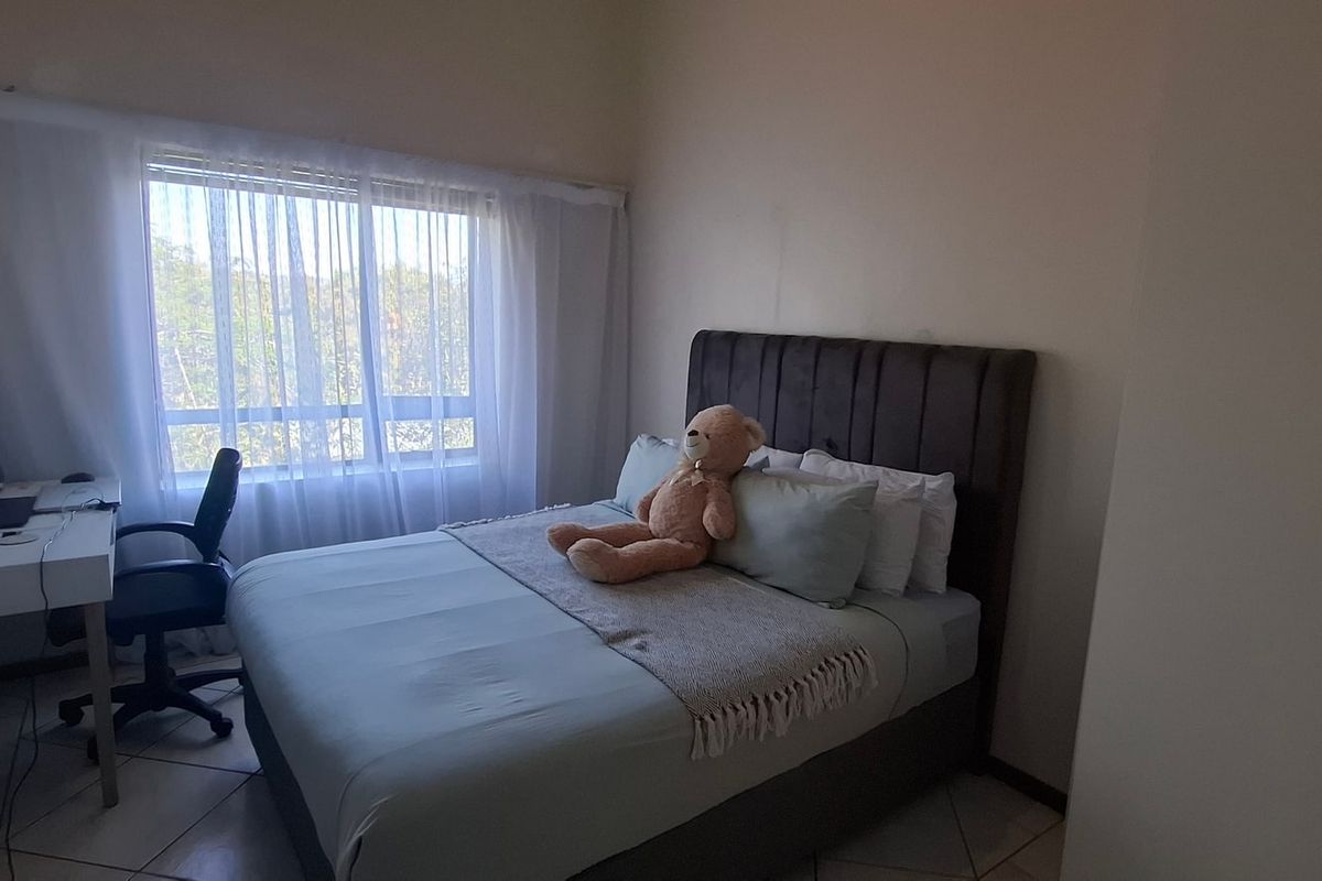 A functional bedroom featuring tiled flooring and a built-in wardrobe, offering a comfortable space with natural light from the window.
