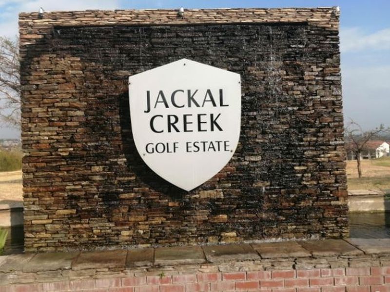 Entrance signage and water feature for Jackal Creek Golf Estate, featuring decorative stone cladding and integrated estate branding.