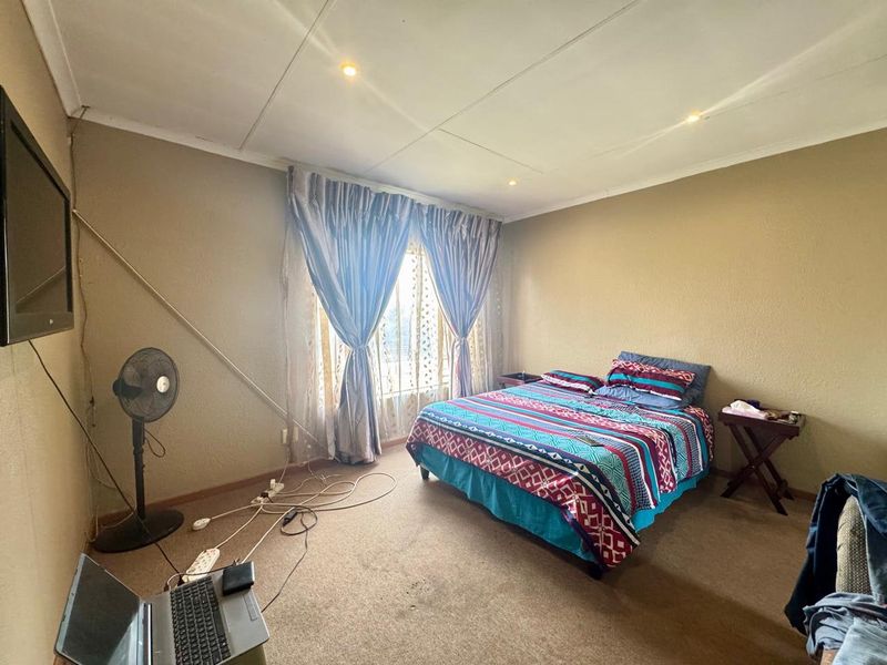 A bedroom featuring recessed ceiling lighting and carpeted flooring, currently requiring cosmetic updates to the ceiling and floor finishes.