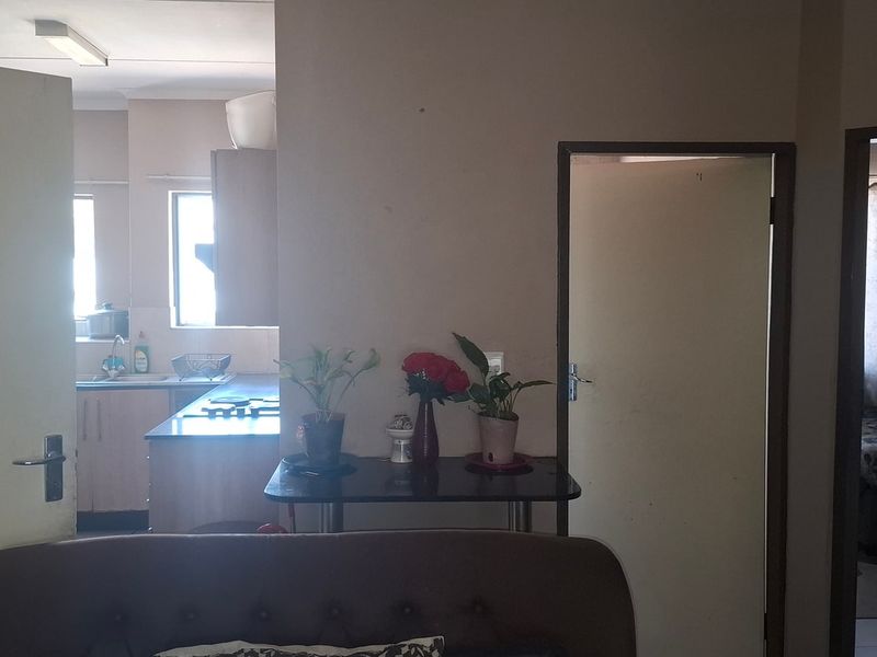 View from the living area looking towards the kitchen, featuring a functional layout with access to adjacent rooms.