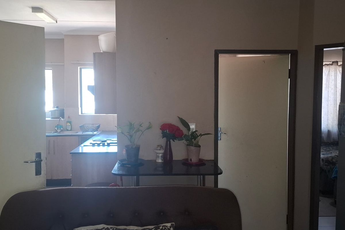 View from the living area looking towards the kitchen, featuring a functional layout with access to adjacent rooms.