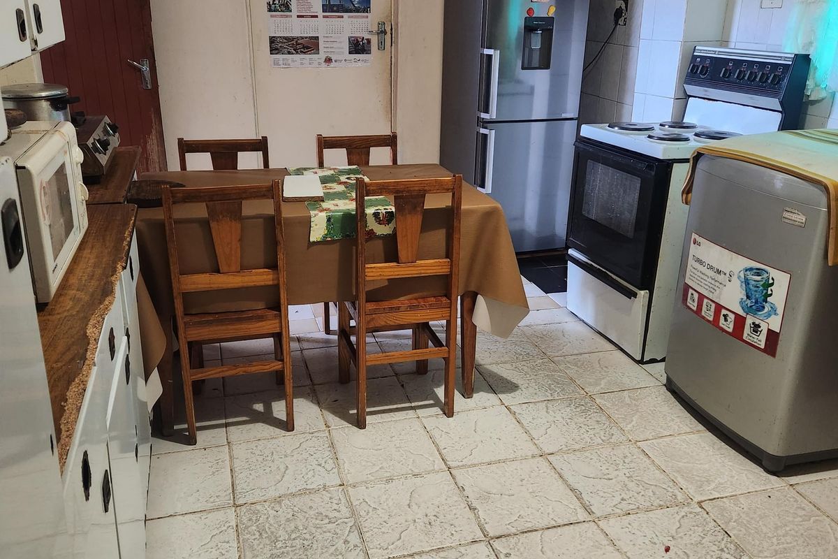 A functional kitchen space featuring tiled flooring, built-in cabinetry, and a freestanding stove, offering potential for modernization and aesthetic updates.