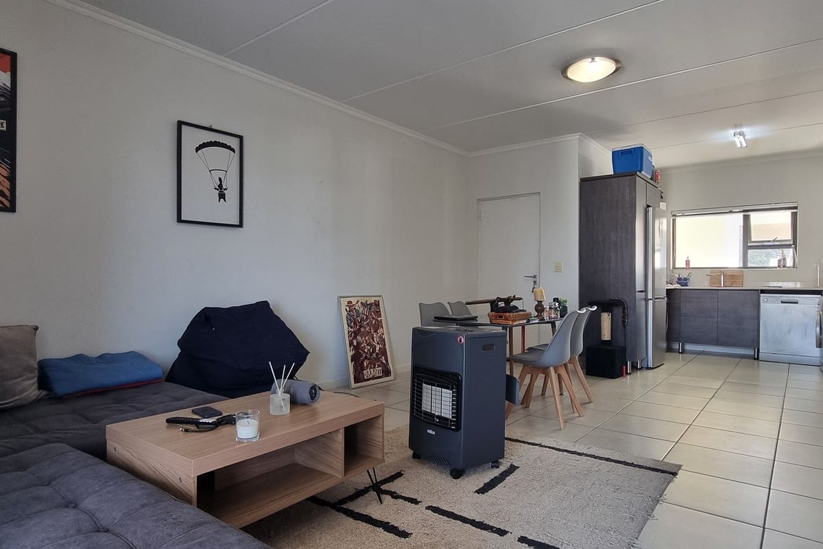 Open-plan living and kitchen area featuring tiled flooring, modern cabinetry, and functional layout suitable for comfortable apartment living.