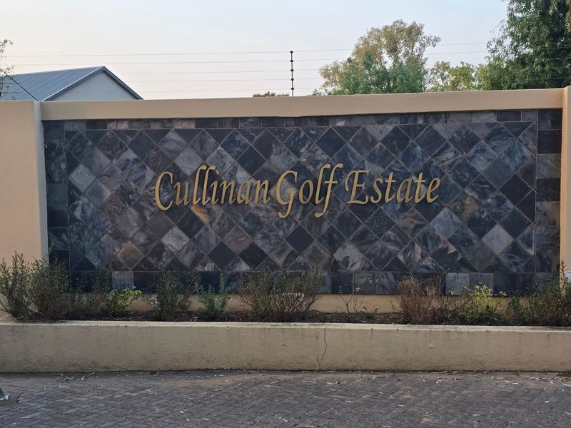 The entrance signage wall for Cullinan Golf Estate, featuring decorative stone cladding and paved driveway access.