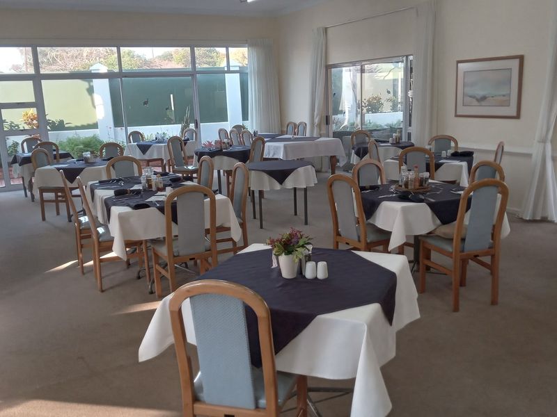 A spacious dining area featuring large sliding glass doors that provide natural light and access to the exterior, with neutral carpeting throughout.