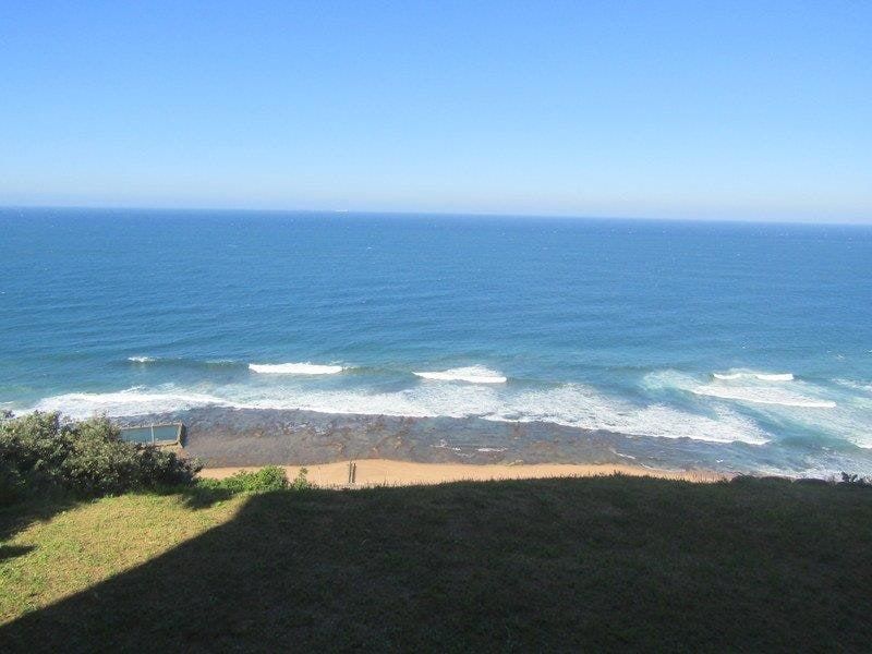 A scenic elevated view overlooking the ocean, coastline, and beach area.
