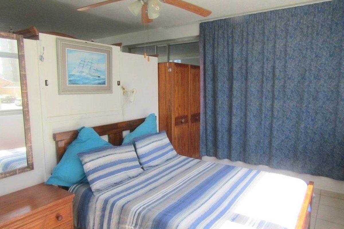 A bedroom featuring tiled flooring, a ceiling fan, and a sliding glass door leading to an outdoor area.