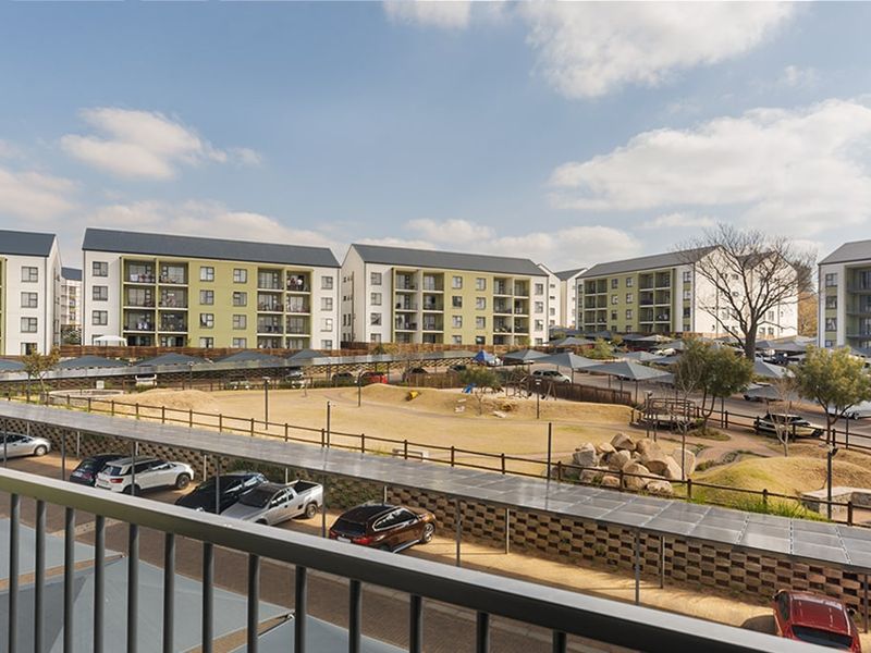 Elevated view overlooking the apartment complex grounds, featuring covered parking bays and landscaped communal areas.