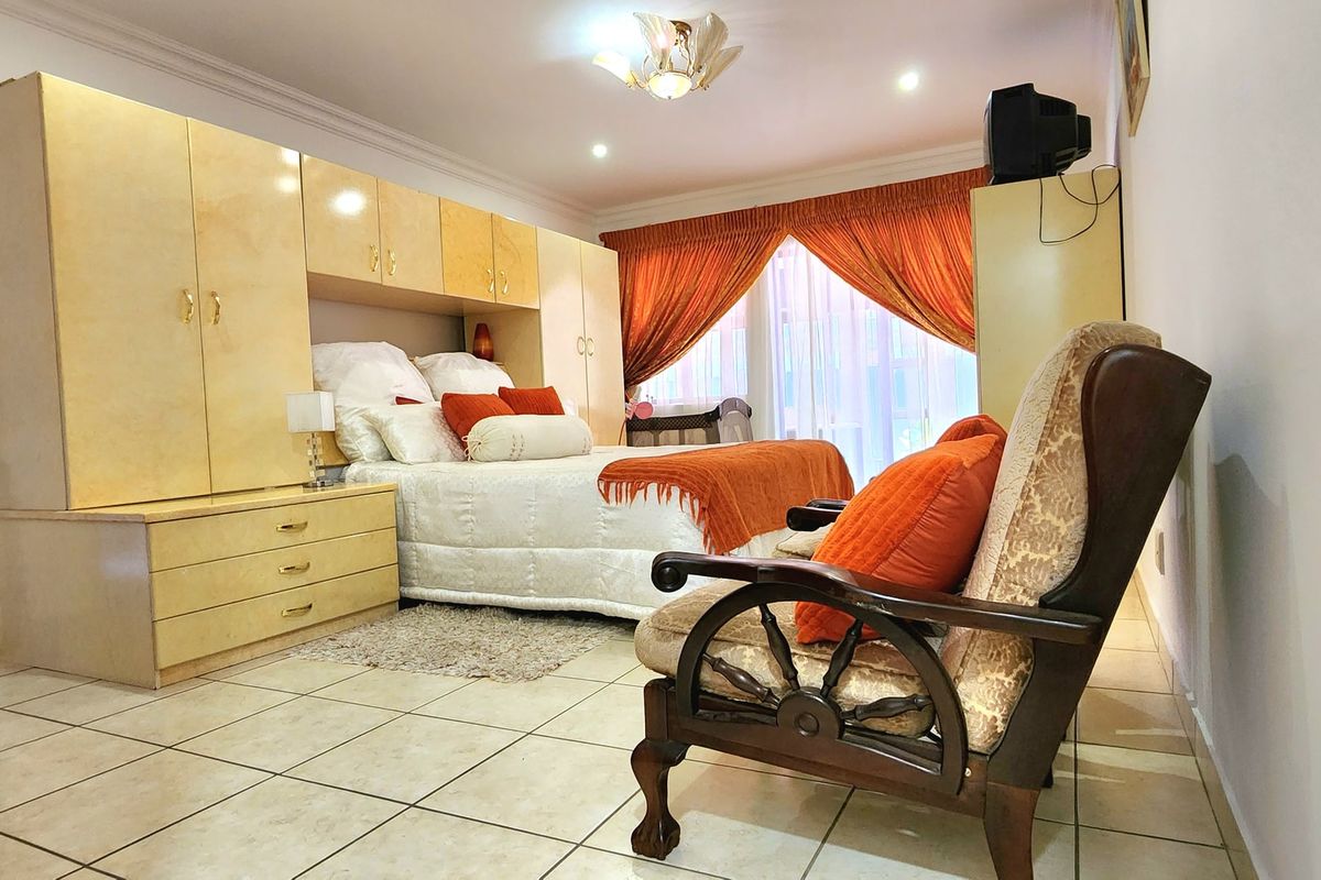 Spacious bedroom featuring extensive built-in cabinetry, tiled flooring, and recessed lighting, offering a functional layout with ample storage space.