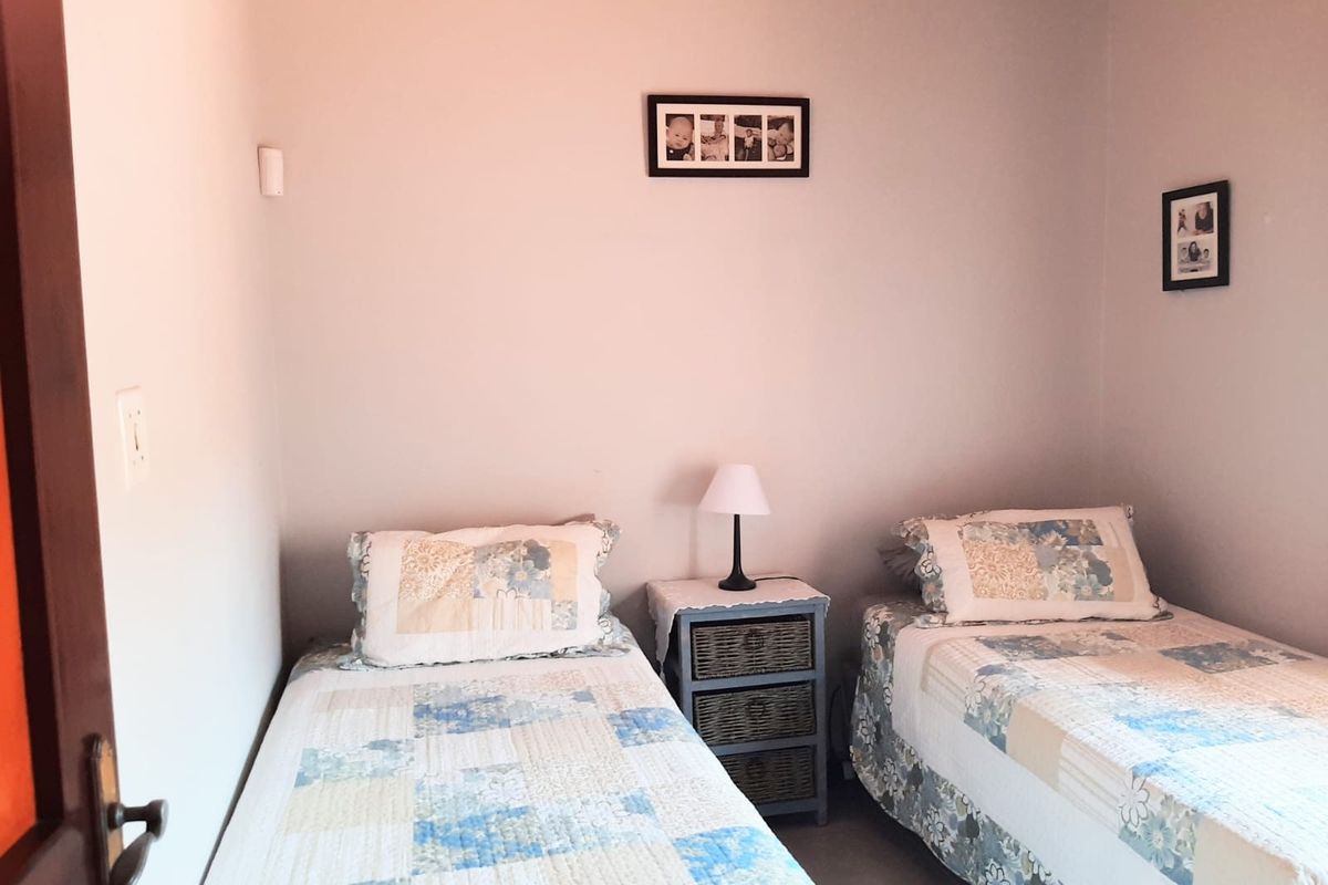 A functional bedroom featuring neutral wall finishes and tiled flooring, suitable for a guest room or children's bedroom.