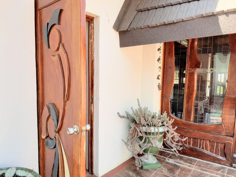 Entrance area featuring a decorative carved wooden door and tiled flooring, providing a unique architectural entry point to the home.