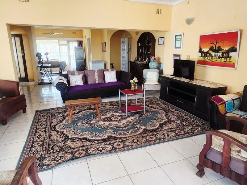 Spacious open-plan living area featuring tiled flooring, arched transitions, and neutral wall finishes, offering a versatile layout for comfortable family living.