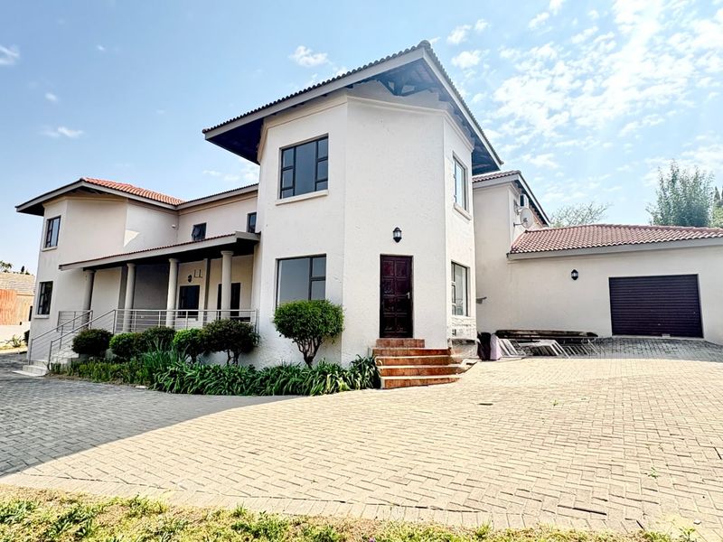 Front elevation of a multi-story residential house featuring a paved driveway, covered porch, and integrated garage.