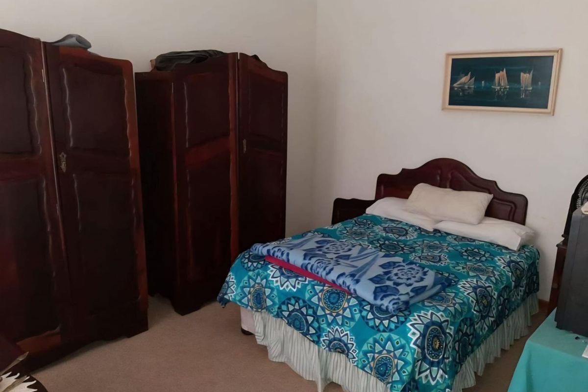 A standard bedroom featuring neutral wall finishes and carpeted flooring, providing a functional space for rest.