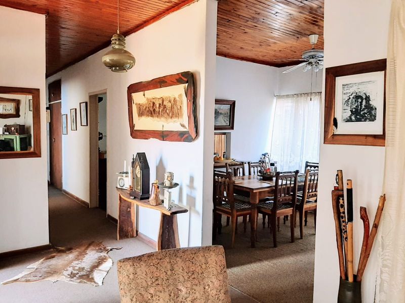 Open plan living and dining area featuring a warm timber tongue and groove ceiling and neutral wall finishes.