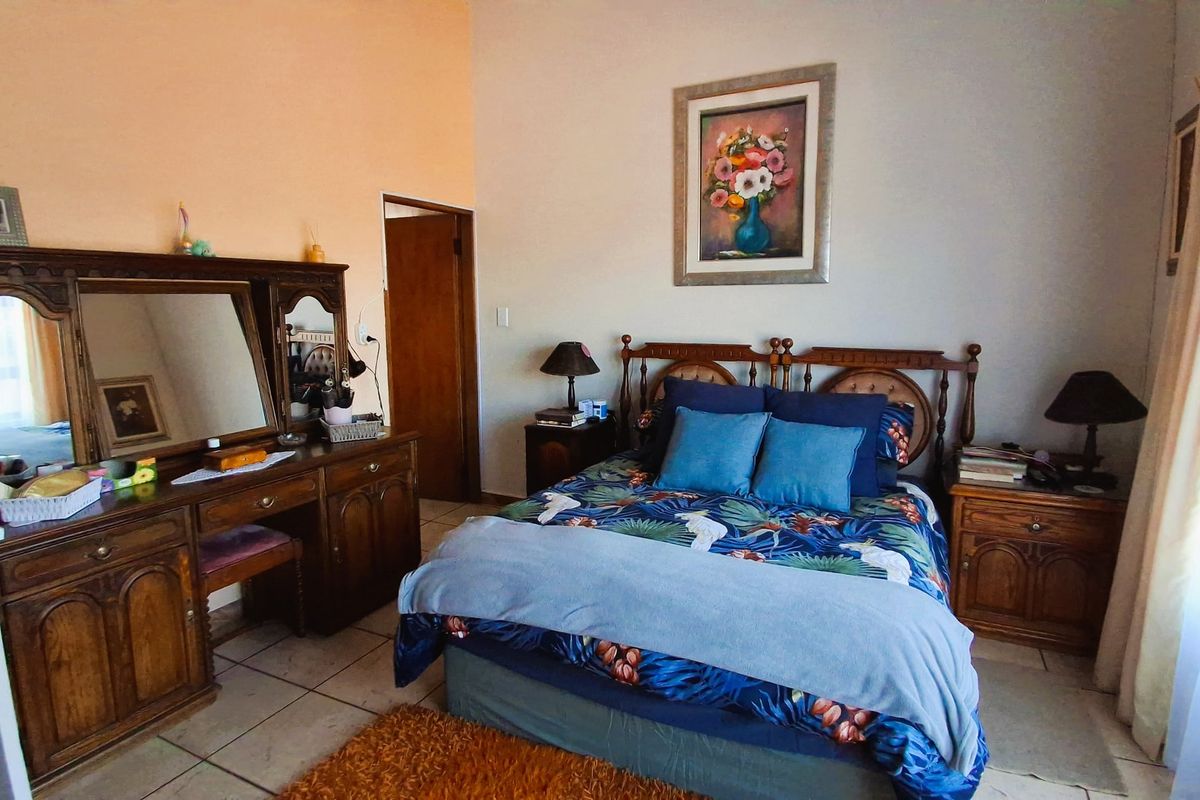 A bedroom featuring tiled flooring and neutral wall finishes, providing a functional space with traditional architectural elements.