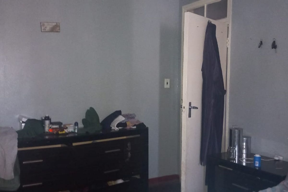 A bedroom featuring painted walls and a standard door, requiring cosmetic updates to improve the overall aesthetic and appeal.