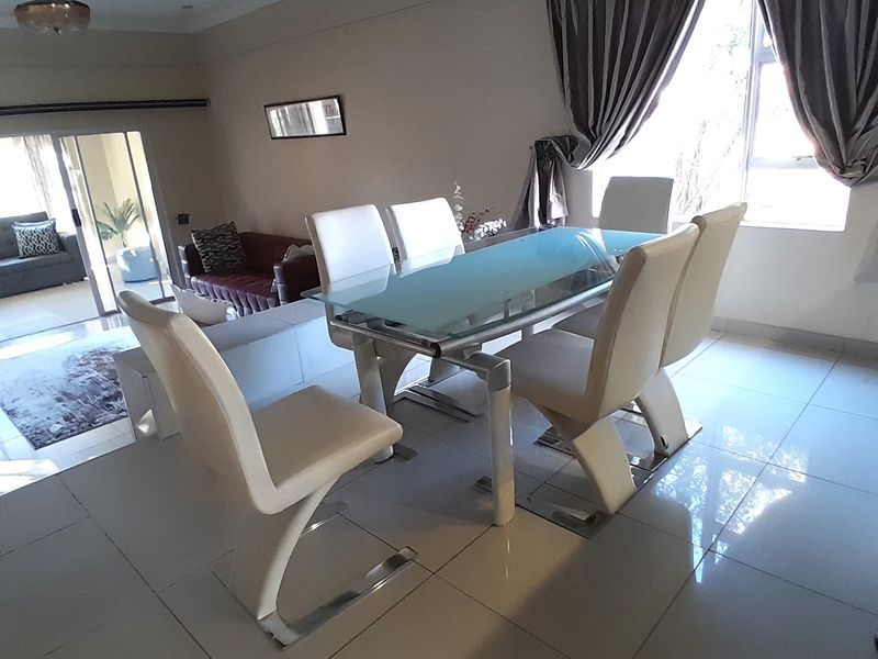 Open plan dining and living area featuring tiled flooring, recessed lighting, and a sliding glass door leading to an outdoor space.