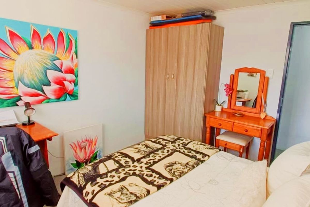 A functional bedroom featuring a built-in wardrobe and neutral wall finishes, providing a comfortable and practical sleeping space.