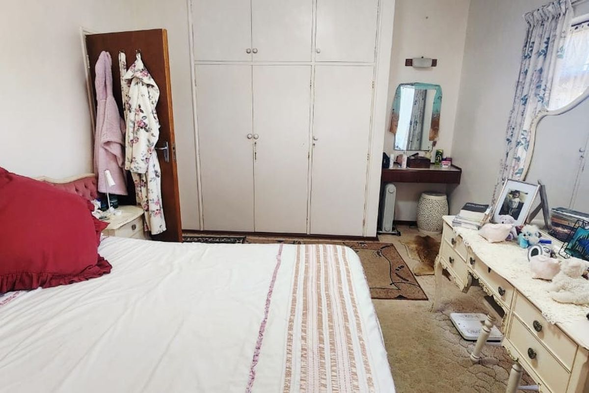 A bedroom featuring built-in wardrobes and a vanity area, offering functional storage and classic layout potential.