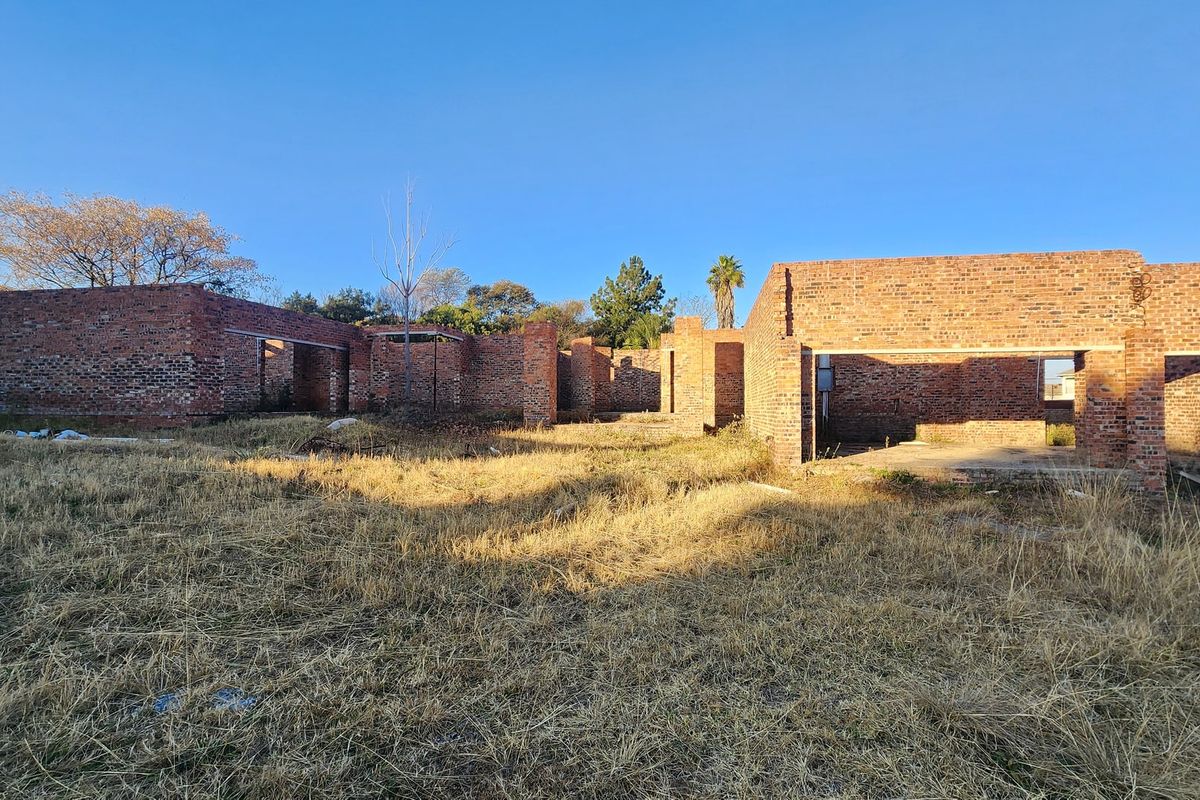 An unfinished residential property structure featuring exposed brick walls and concrete foundations, offering a blank canvas for completion and custom development.