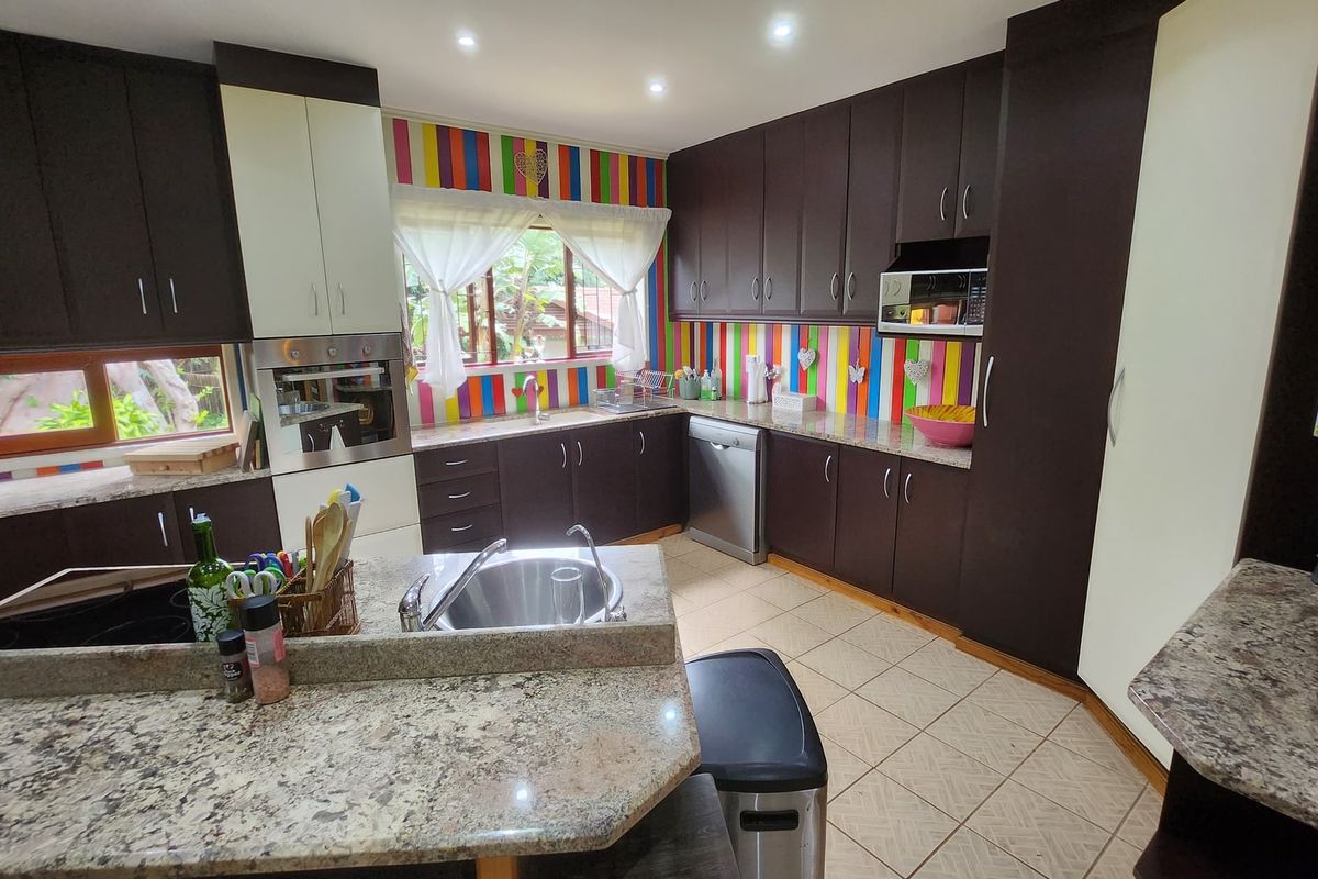 A functional kitchen featuring granite countertops, built-in appliances, and ample cabinetry, offering a practical layout for daily meal preparation.