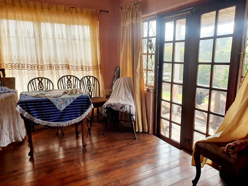 Dining area featuring original timber flooring and classic french doors providing natural light and access to the outdoor space.