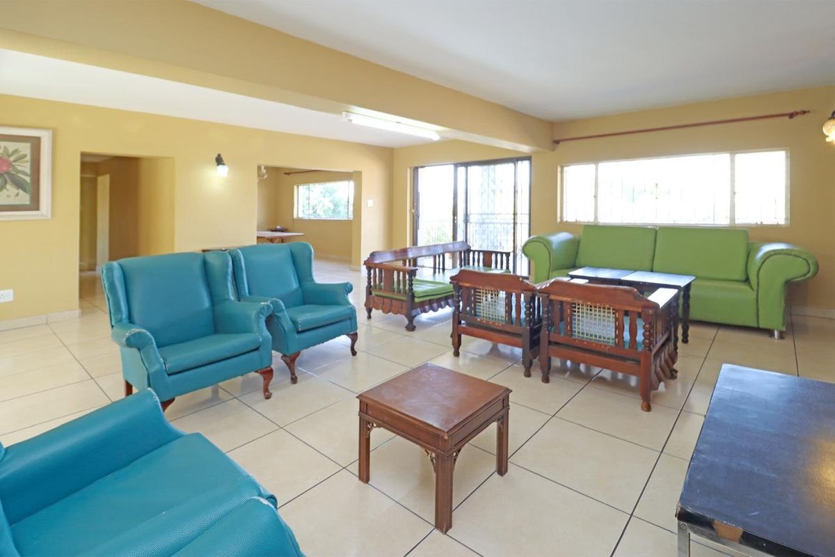 Spacious living area featuring large tiled floors, sliding glass doors providing natural light, and neutral wall finishes.