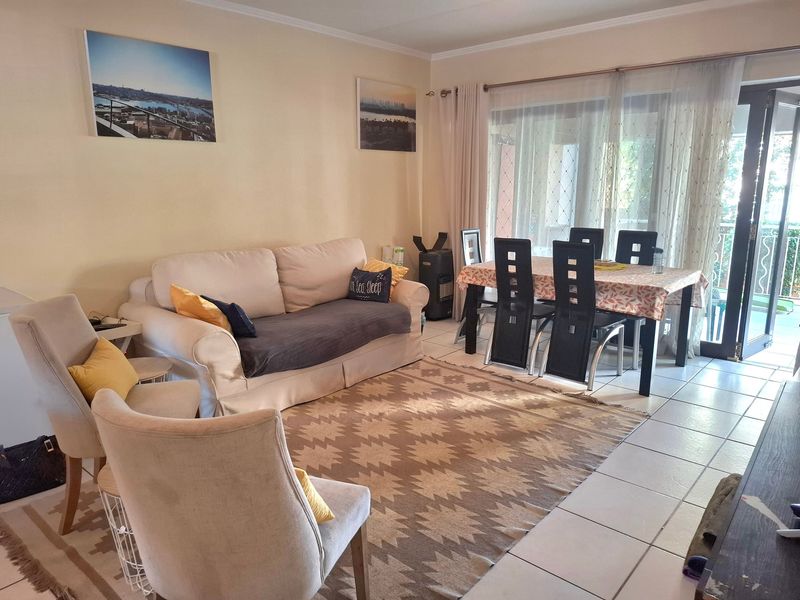 Open plan living and dining area featuring tiled flooring and large sliding glass doors providing access to the outdoor space.