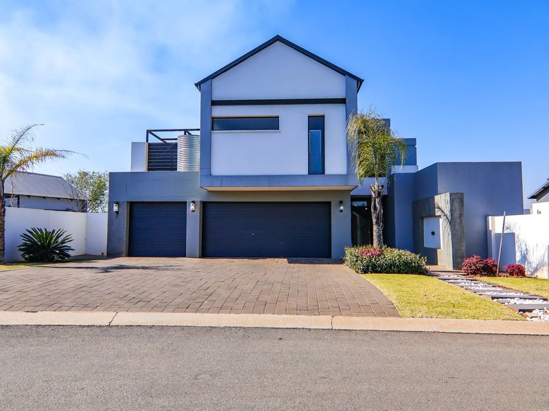 Modern double-story residential home featuring a paved driveway, double garage, and contemporary architectural facade.