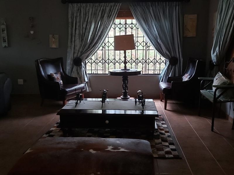 A cozy living room featuring tiled flooring and a window fitted with a security gate, providing a comfortable and secure living space.