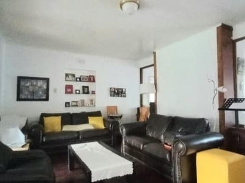 A living room featuring sliding glass doors with security bars, a built-in cabinet, and a frosted glass partition.