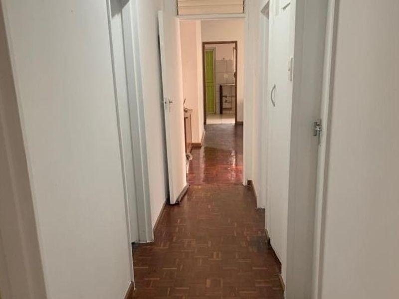 A functional hallway featuring parquet flooring and built-in storage cupboards, providing access to other areas of the home.