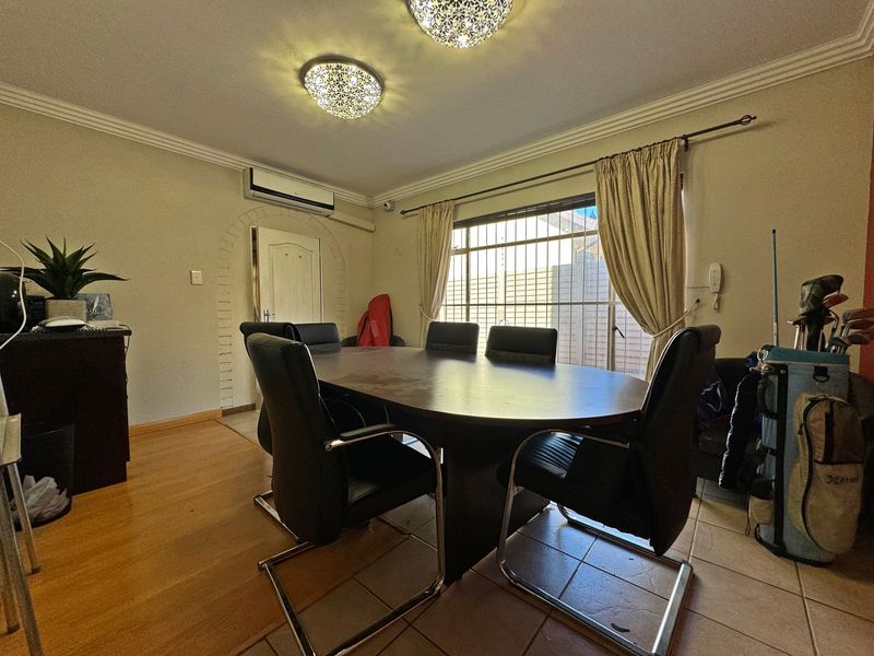 Dining room featuring tiled flooring, split-system air conditioning, and an arched doorway, providing a functional space for family meals.