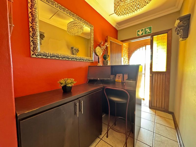 An entrance area featuring tiled flooring, coved ceilings, and built-in cabinetry, providing a functional reception or workspace transition point.