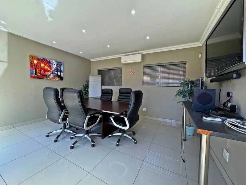 A functional home office space featuring tiled flooring, recessed lighting, and a wall-mounted air conditioning unit.