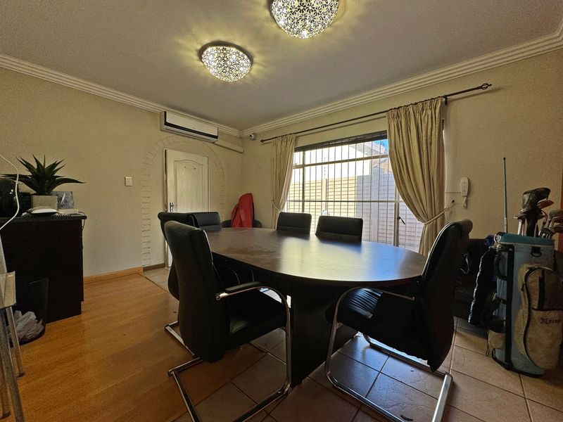Dining room featuring tiled flooring, decorative ceiling lighting, a split-system air conditioner, and an arched doorway leading to an adjacent space.
