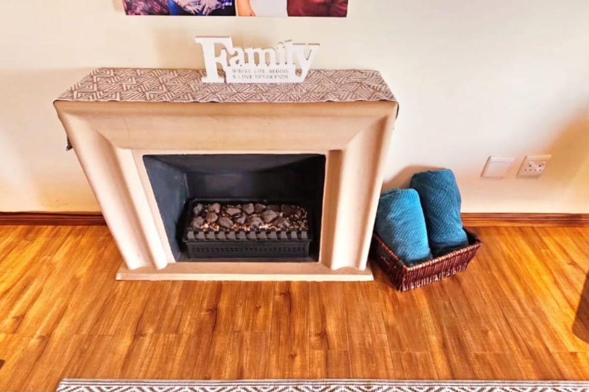 A living room area featuring a built-in fireplace and warm-toned laminate flooring.