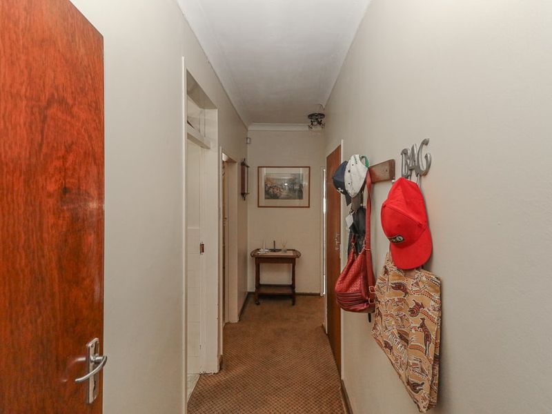 A functional residential hallway featuring carpeted flooring and multiple interior doors providing access to adjacent rooms.