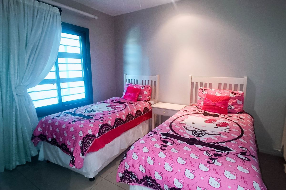 A bedroom featuring tiled flooring and built-in cupboards, providing functional storage space within the apartment.