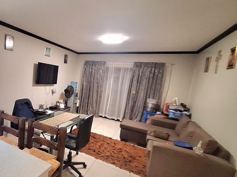 Open plan living area featuring tiled flooring and a sliding glass door leading to an outdoor space.