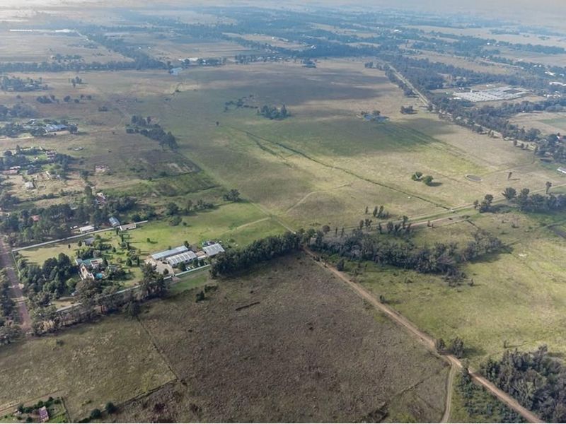 An aerial view of the expansive farm property, showcasing the surrounding landscape, access roads, and the main building cluster.