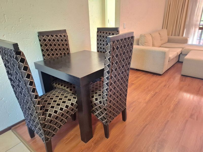 Open plan living and dining area featuring laminate flooring and textured wall finishes.