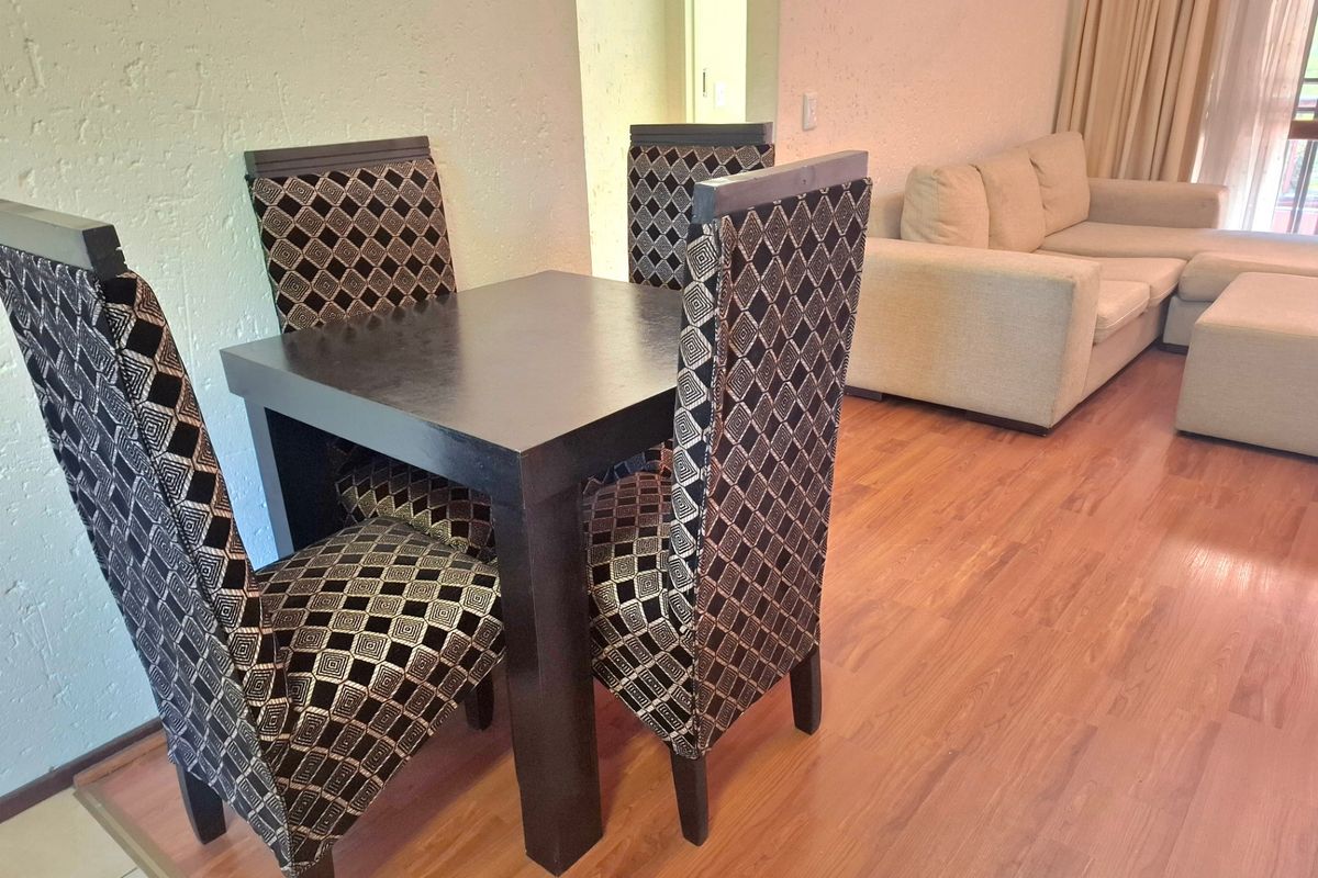 Open plan living and dining area featuring laminate flooring and textured wall finishes.