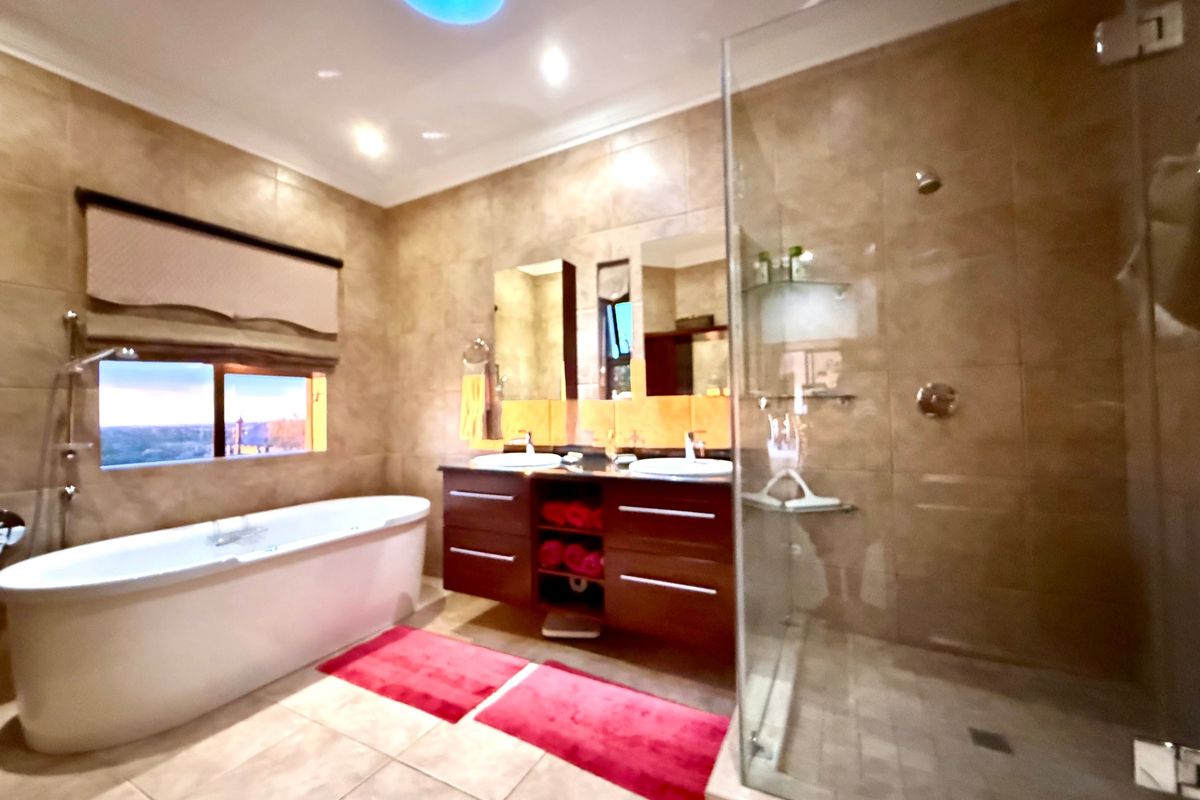 Modern bathroom featuring a freestanding bathtub, a glass-enclosed walk-in shower, and a double vanity with integrated sinks and storage cabinetry.