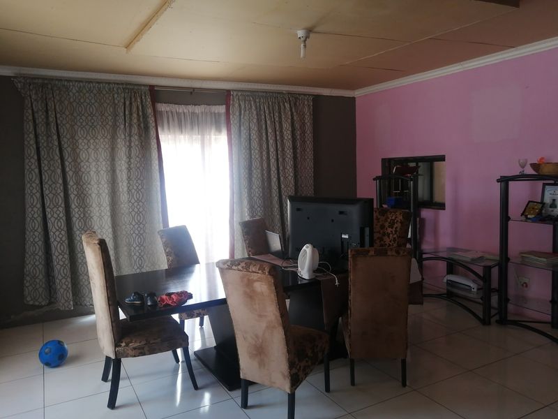 Dining room featuring tiled flooring, ceiling cornice, and access to a sliding door, requiring cosmetic updates to the ceiling and wall finishes.