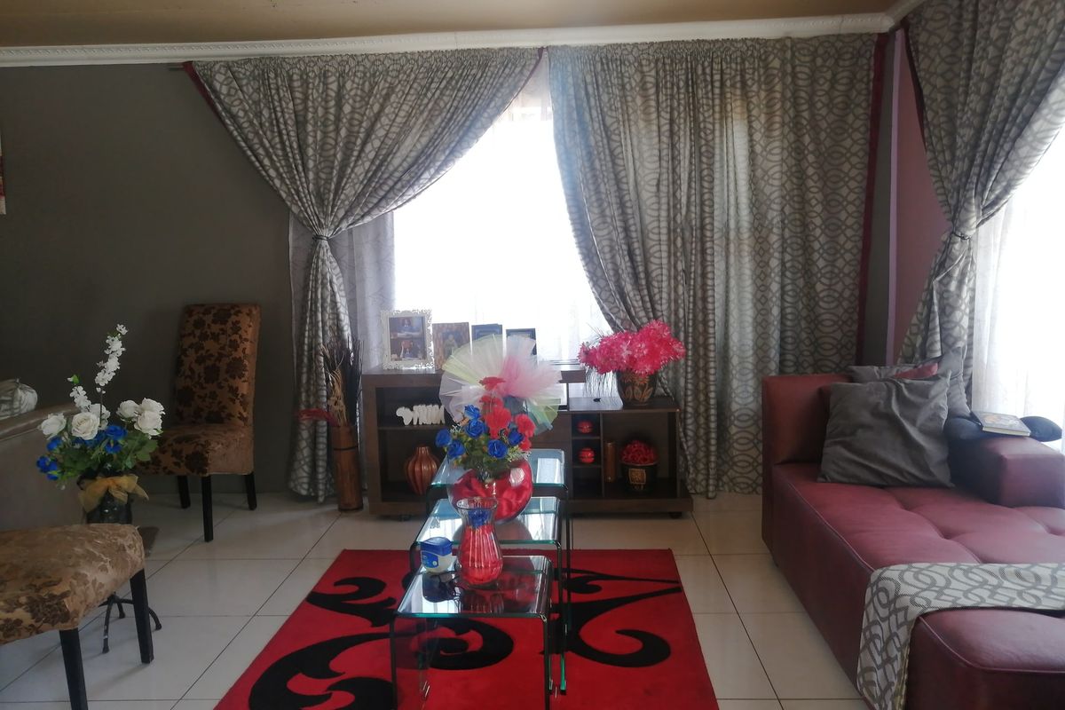 A living room featuring tiled flooring and decorative ceiling cornicing, providing a functional space for relaxation.