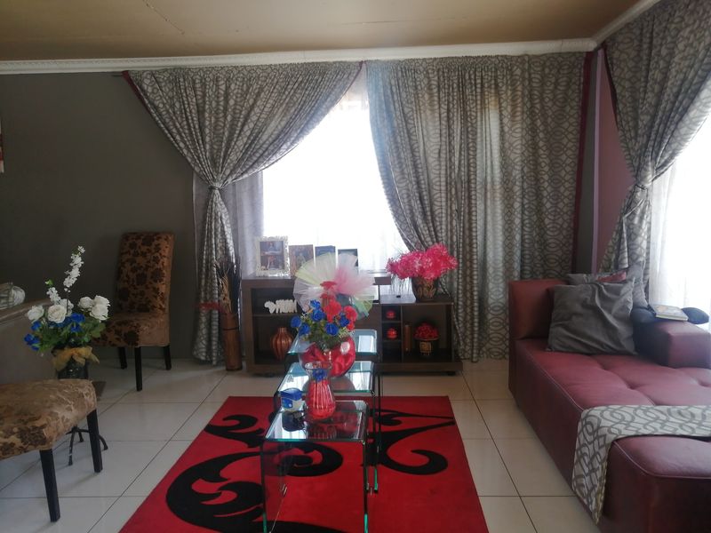 A living room featuring tiled flooring and decorative ceiling cornicing, providing a functional space for relaxation.