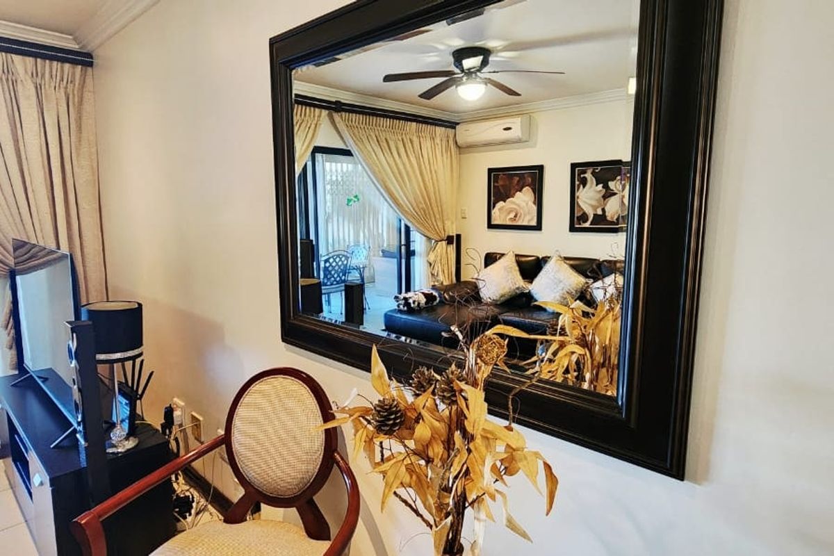 A well-maintained living room featuring a ceiling fan, split-system air conditioning, and large sliding glass doors that provide access to the outdoor area.